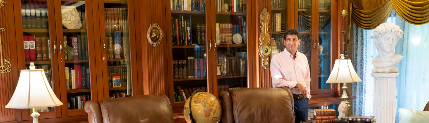 Owner standing proud of his private library collection, a luxurious setting for your wedding venue.